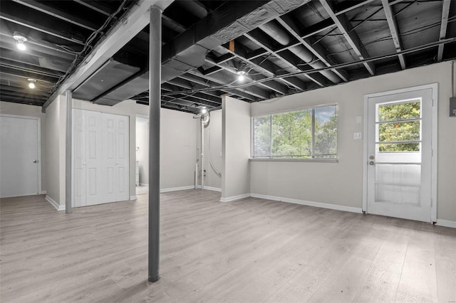 below grade area featuring wood finished floors, a wealth of natural light, and baseboards