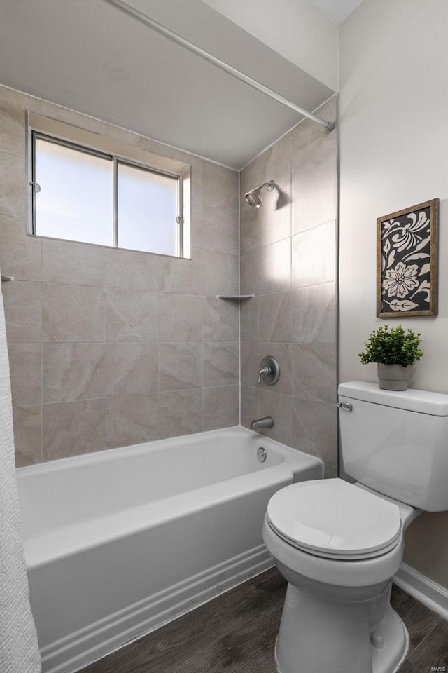 full bathroom featuring toilet, washtub / shower combination, and wood finished floors