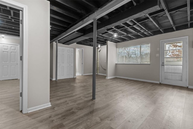 basement featuring baseboards and wood finished floors