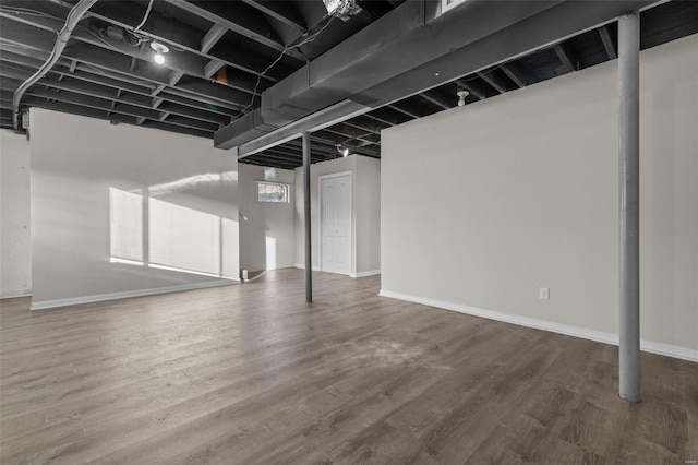 below grade area featuring baseboards and wood finished floors