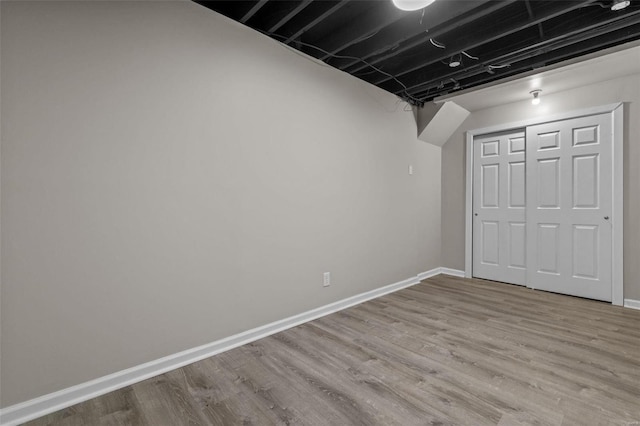 finished basement featuring baseboards and wood finished floors