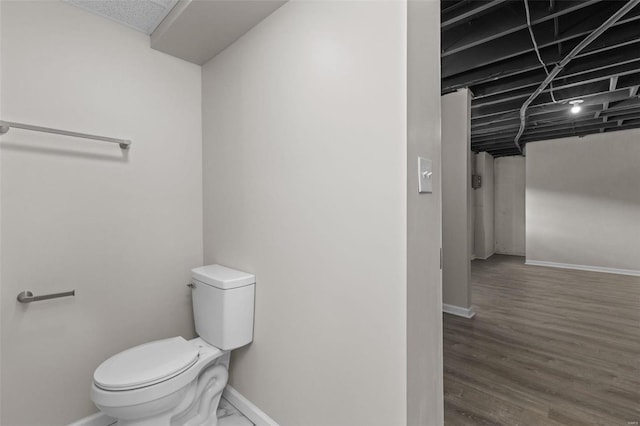 bathroom featuring baseboards, toilet, and wood finished floors