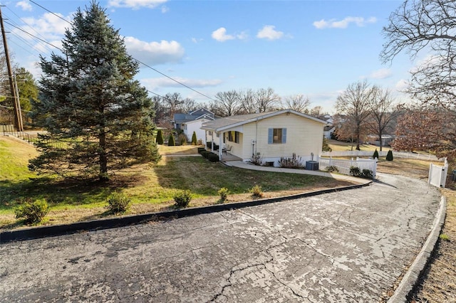 view of property exterior with a yard, cooling unit, and fence