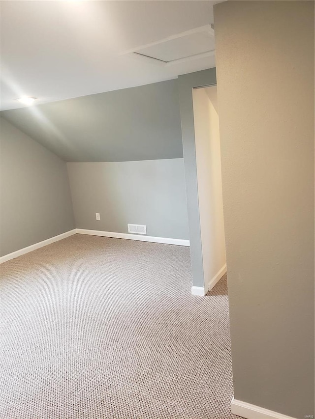 bonus room with carpet flooring and vaulted ceiling