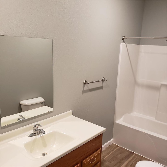 full bathroom featuring wood-type flooring, vanity, toilet, and  shower combination