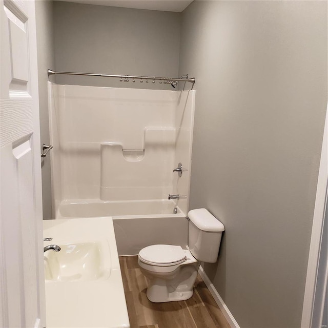 full bathroom with  shower combination, toilet, wood-type flooring, and sink