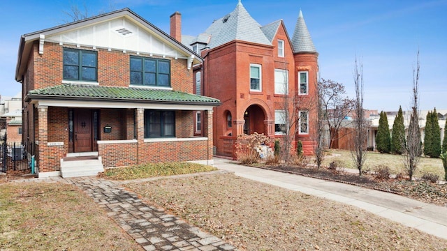 view of front of property with covered porch, brick siding, and board and batten siding