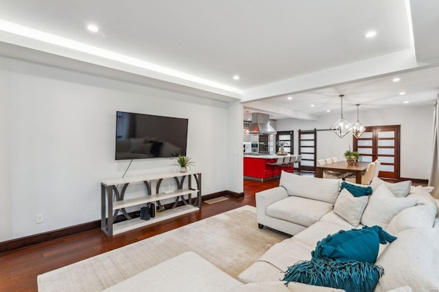 living room with dark wood-style floors, baseboards, a notable chandelier, and recessed lighting