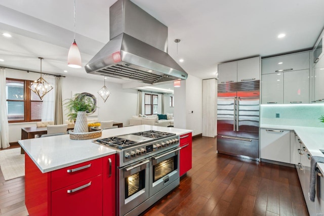 kitchen featuring high end appliances, dark wood-type flooring, a center island, island exhaust hood, and pendant lighting