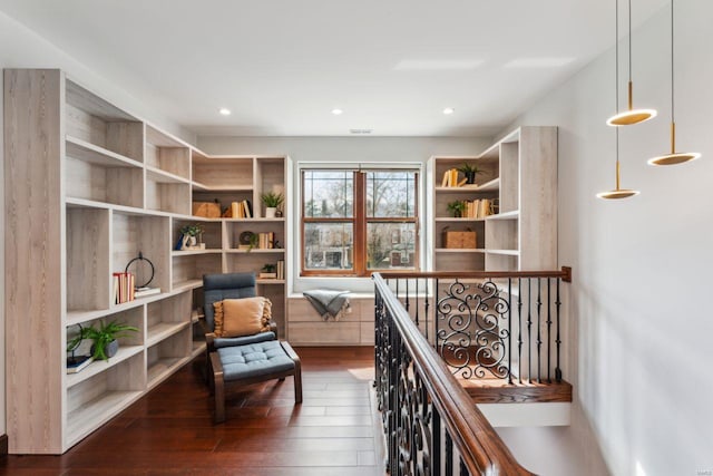 sitting room featuring dark wood-style floors, recessed lighting, and an upstairs landing