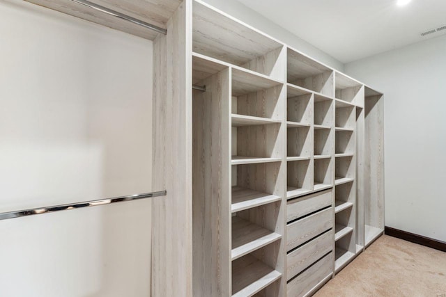 spacious closet with visible vents and light colored carpet