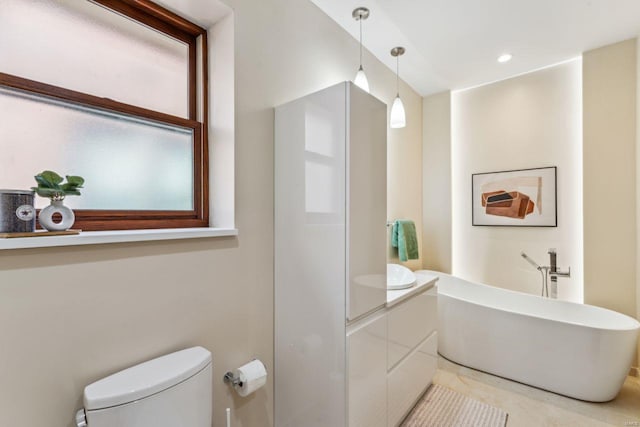 bathroom featuring a freestanding bath, toilet, and recessed lighting