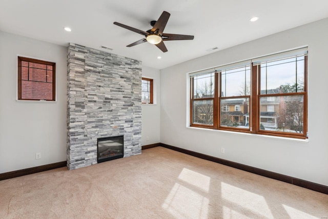 unfurnished living room featuring baseboards, a fireplace, visible vents, and light colored carpet