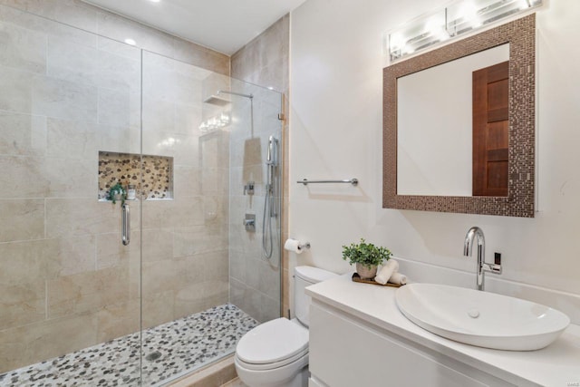 full bath with vanity, a shower stall, and toilet