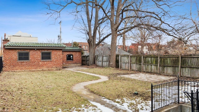 yard covered in snow featuring a fenced backyard and a patio