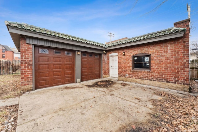 exterior space featuring a tiled roof, brick siding, driveway, and a chimney