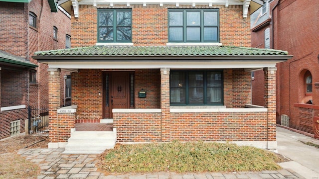 view of front of home with brick siding and a porch