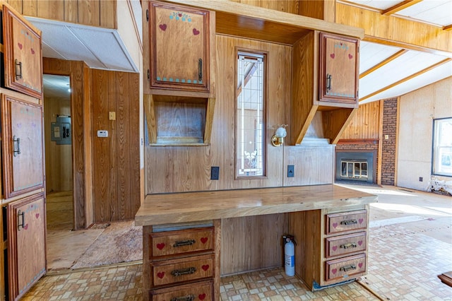 kitchen with wood walls, a healthy amount of sunlight, a fireplace, and wood counters