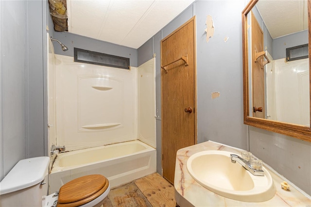 full bathroom with a textured ceiling, vanity, washtub / shower combination, and toilet