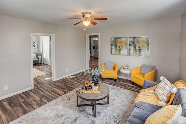 living room with dark hardwood / wood-style floors and ceiling fan