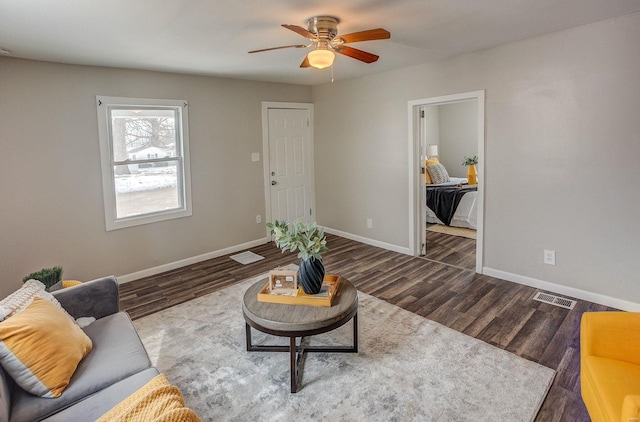 living room with ceiling fan and dark hardwood / wood-style flooring