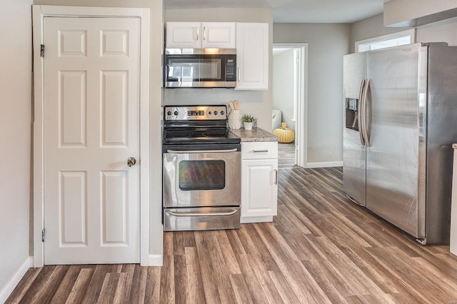 kitchen featuring white cabinets, dark hardwood / wood-style flooring, light stone countertops, and appliances with stainless steel finishes