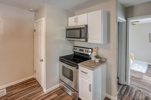 kitchen with light stone counters, dark hardwood / wood-style flooring, white cabinetry, and appliances with stainless steel finishes