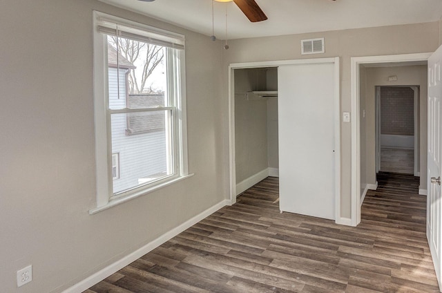 unfurnished bedroom featuring a closet, ceiling fan, and dark hardwood / wood-style flooring