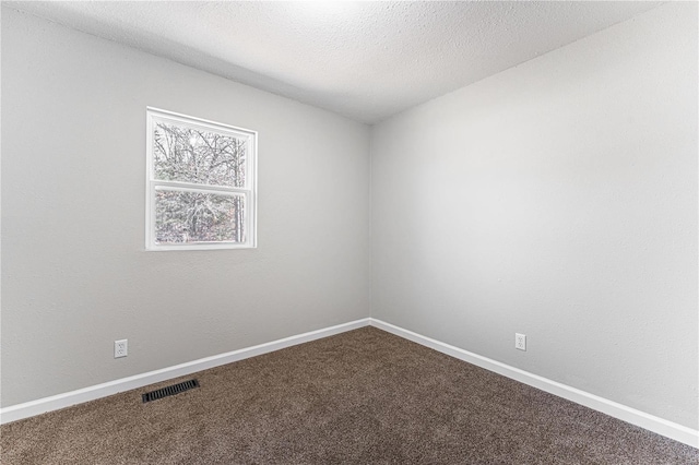 carpeted spare room featuring a textured ceiling