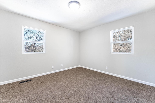 empty room with carpet floors and a textured ceiling