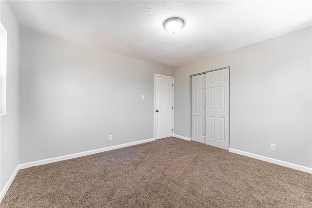 unfurnished bedroom featuring carpet flooring, a closet, and a textured ceiling