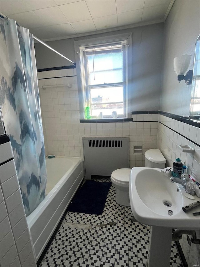 bathroom featuring tile walls, toilet, radiator heating unit, and shower / bathtub combination with curtain