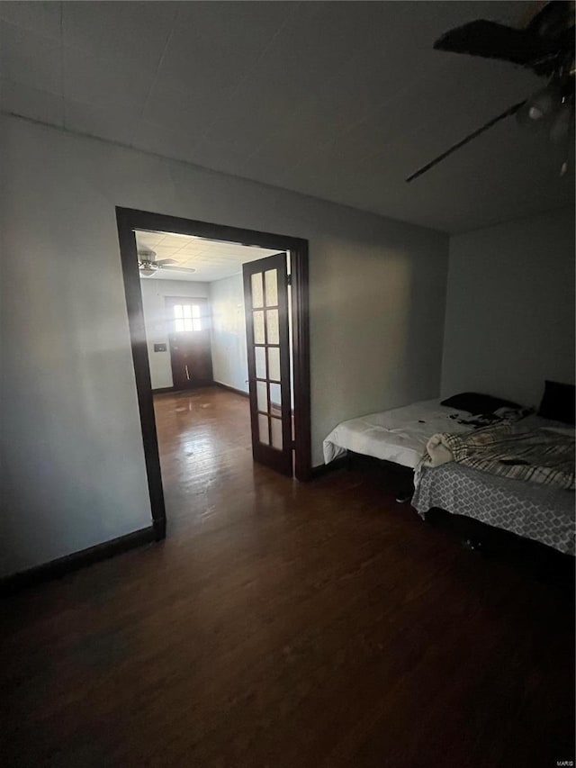 unfurnished bedroom with ceiling fan and dark hardwood / wood-style floors