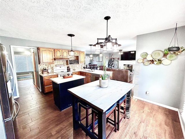 kitchen featuring backsplash, a center island, wood-type flooring, sink, and stainless steel appliances