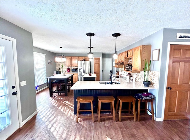 kitchen with a kitchen breakfast bar, stainless steel appliances, kitchen peninsula, and sink