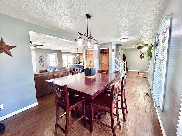 dining space with a textured ceiling, ceiling fan, and hardwood / wood-style flooring