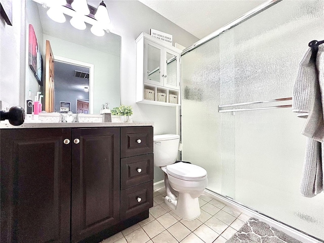 bathroom with toilet, tile patterned flooring, walk in shower, and vanity