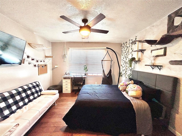 bedroom featuring ceiling fan, a textured ceiling, and hardwood / wood-style floors