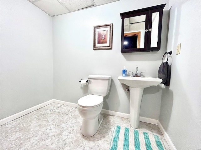 bathroom featuring sink, toilet, and a paneled ceiling