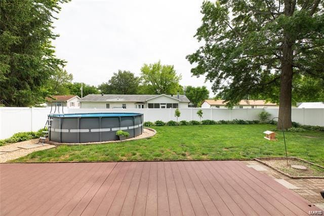 wooden terrace featuring a fenced in pool and a yard