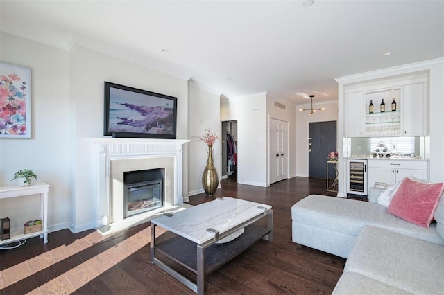 living room with dark wood-type flooring, beverage cooler, and ornamental molding