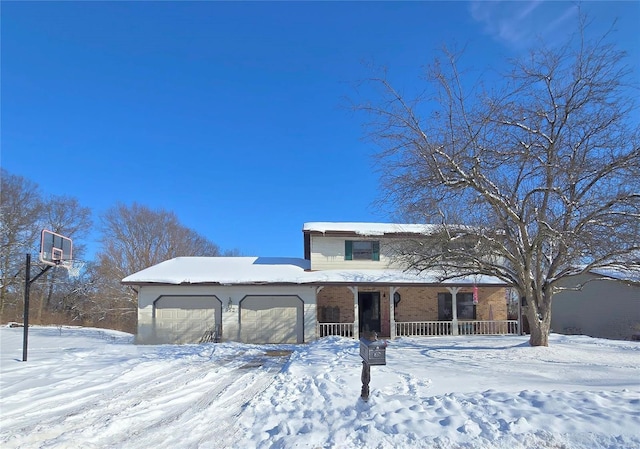 view of front of property featuring a porch, brick siding, and a garage