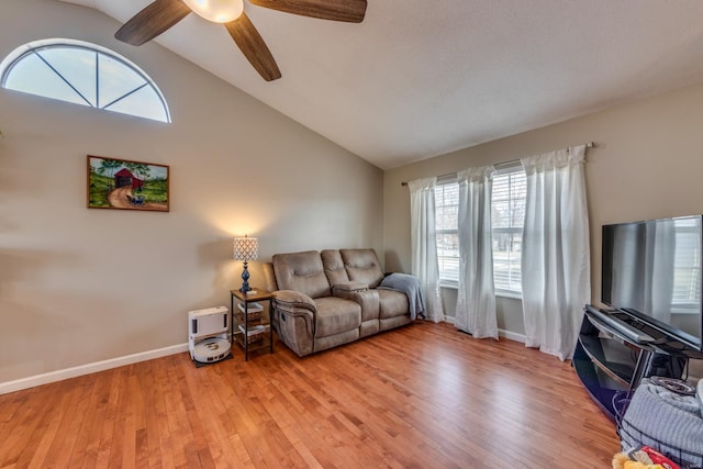 living room with ceiling fan, high vaulted ceiling, and light hardwood / wood-style flooring