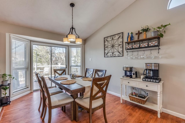 dining room featuring vaulted ceiling and hardwood / wood-style floors