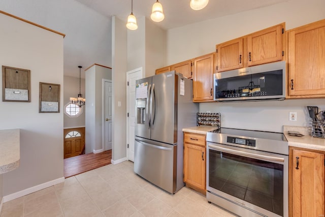 kitchen featuring pendant lighting, appliances with stainless steel finishes, and light tile patterned floors