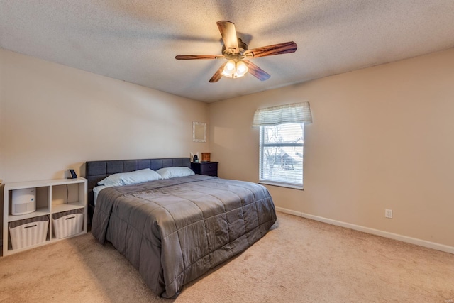 carpeted bedroom with ceiling fan and a textured ceiling