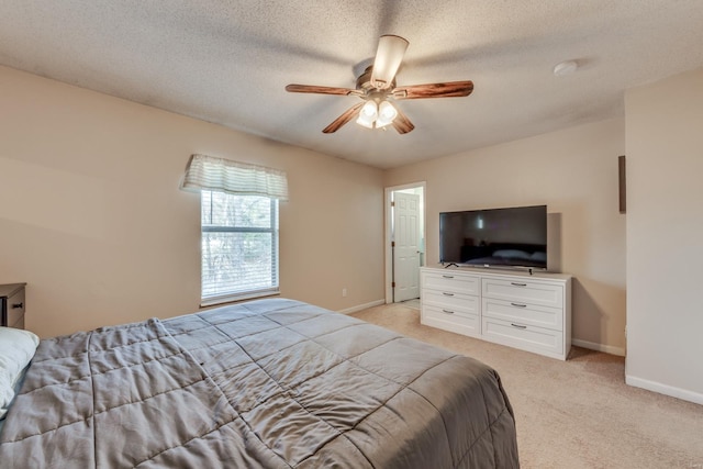 bedroom featuring ceiling fan, light carpet, and a textured ceiling