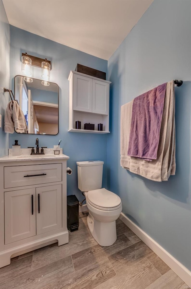 bathroom featuring vanity, hardwood / wood-style floors, and toilet