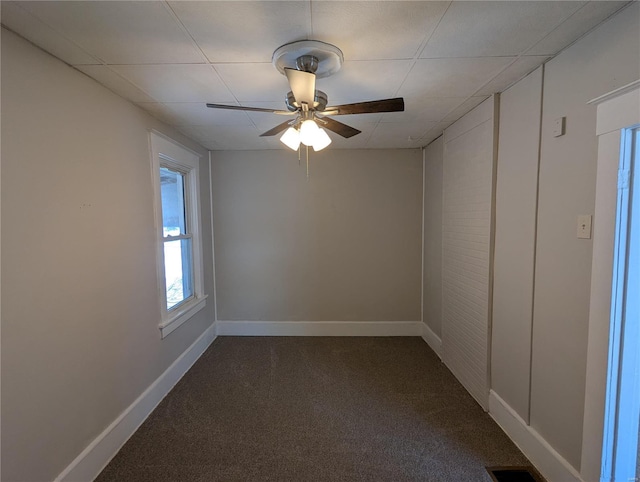 empty room featuring ceiling fan and carpet