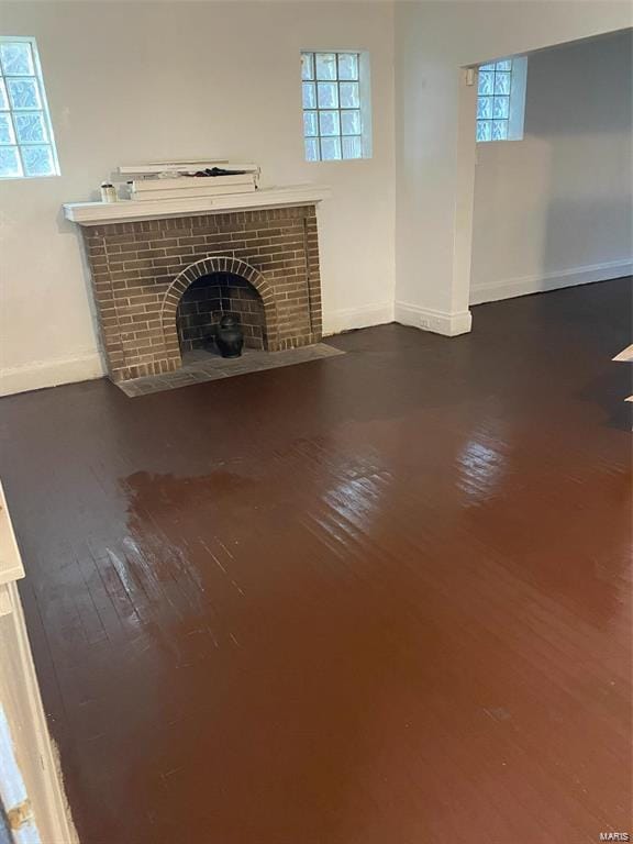 unfurnished living room featuring a fireplace and dark wood-type flooring